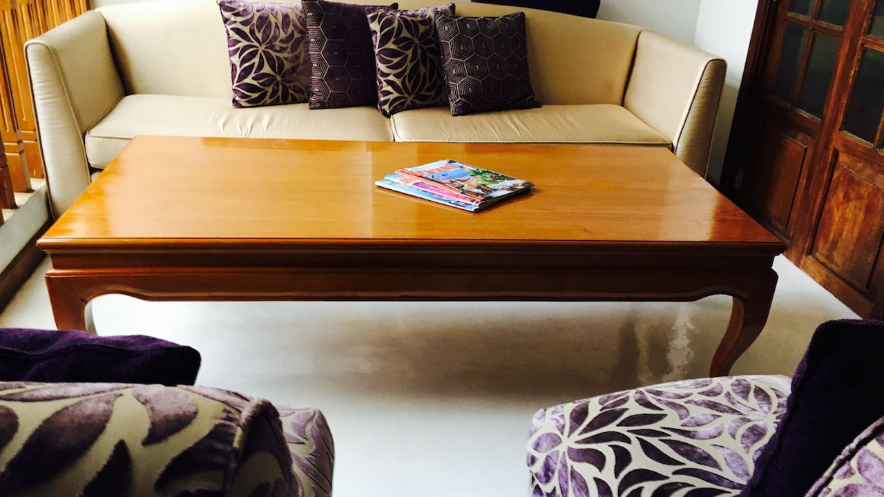 Living room with a beige sofa, wooden coffee table, and patterned cushions.