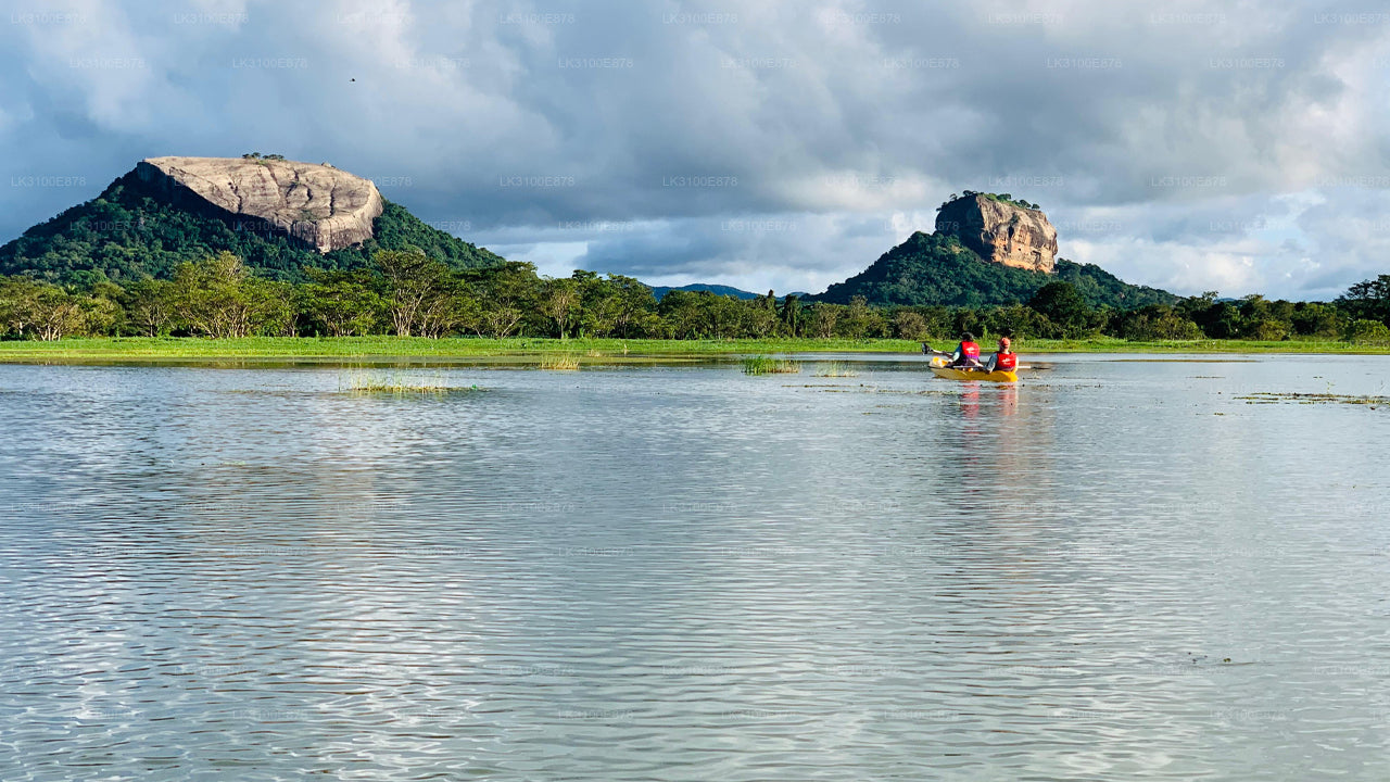 Two people in a boat on a calm lake with mountains in the background
